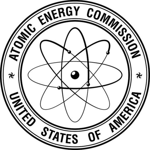 The seal of the Atomic Energy Commission of the United States of America. The seal is circular with the words "Atomic Energy Commission" at the top and "United States of America" at the bottom. In the center, there is a stylized atomic symbol with an electron orbiting a nucleus, representing nuclear energy.  In 1964 the AEC established the first standards for Nuclear Instrumentation Modules.